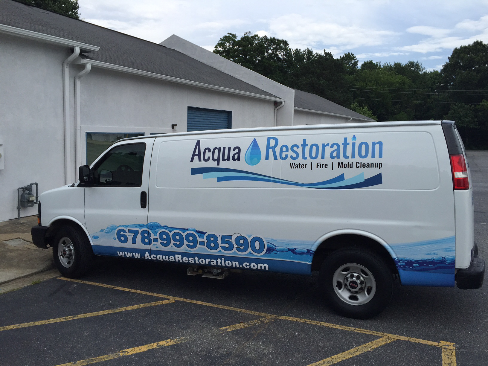 White Acqua Restoration service van with blue water graphics, blue branding and large contact lettering.