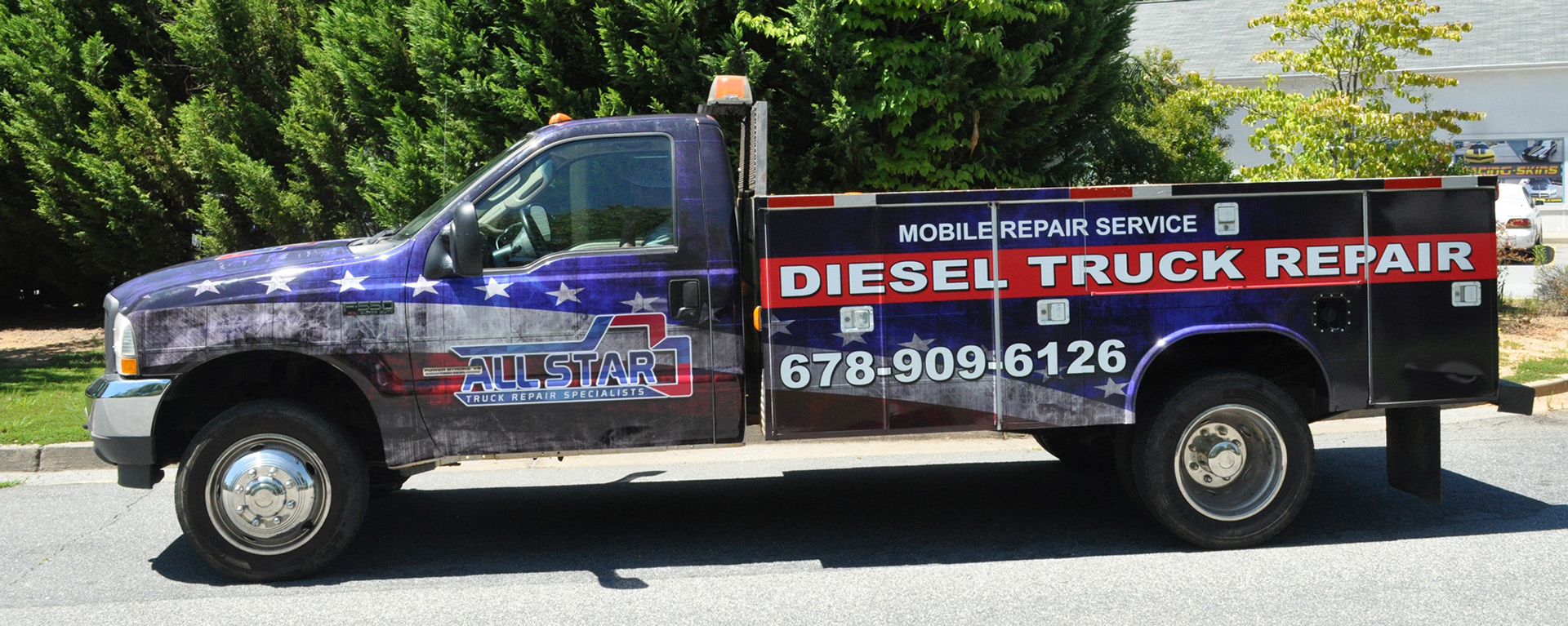 AllStar service-body truck with a red, white and blue stars-and-stripes wrap and diesel truck repair lettering.