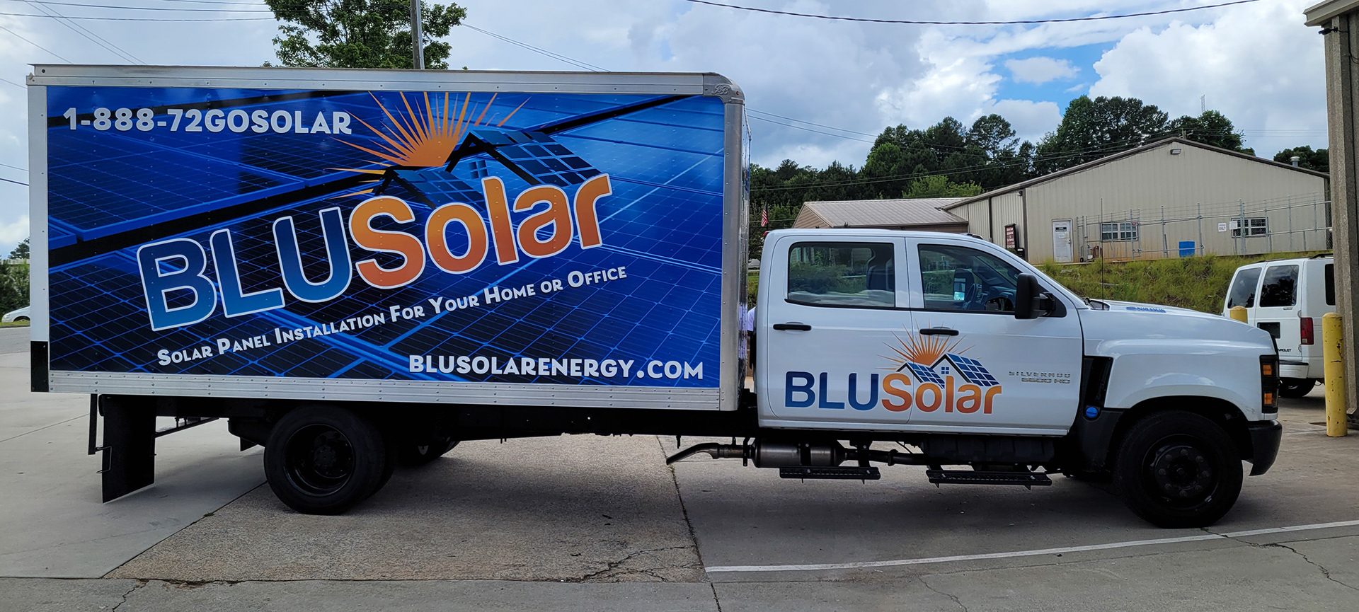BLUSolar box truck with blue solar-panel graphics, an orange sun and matching branding on its white cab.