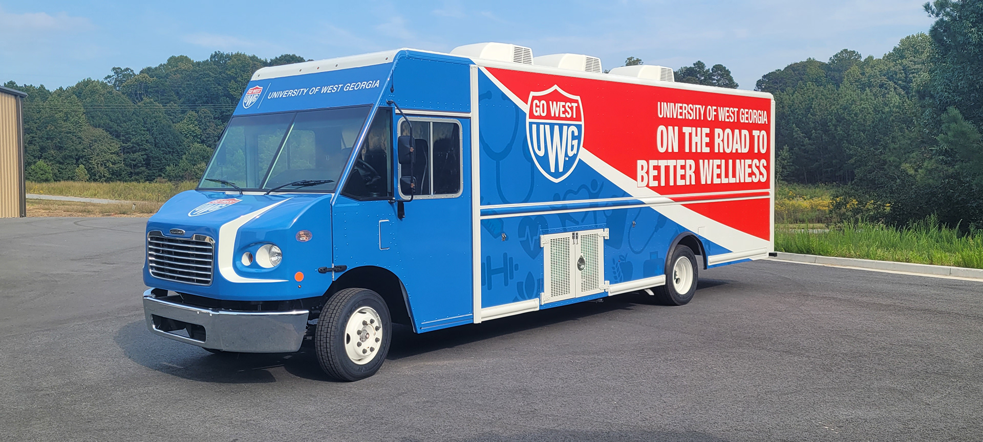 University of West Georgia mobile wellness truck with blue, red and white graphics, seen from the front and side.